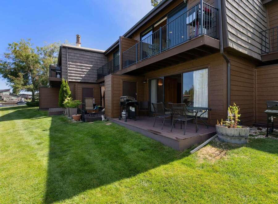 Enjoy outdoor living with this charming patio featuring a grill and dining set, perfect for summer barbecues.