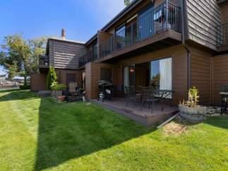 Enjoy outdoor living with this charming patio featuring a grill and dining set, perfect for summer barbecues.