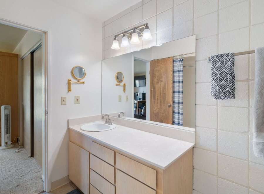 This bathroom features a spacious vanity with ample storage and a clean white countertop.