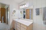 This bathroom features a spacious vanity with ample storage and a clean white countertop.