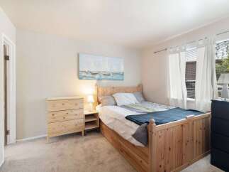 This cozy bedroom features a charming wooden bed frame with built-in storage, complemented by a matching pine dresser.