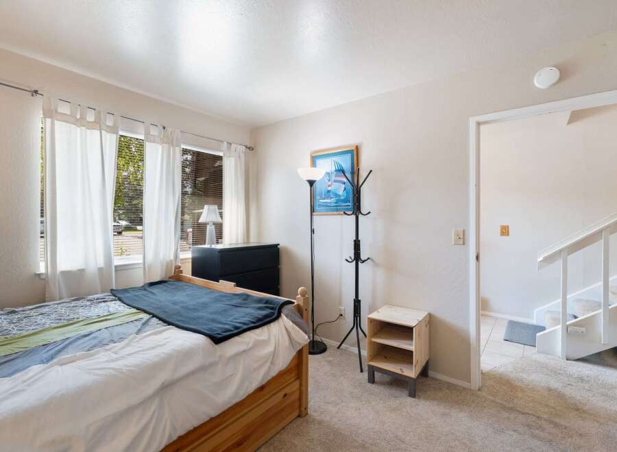 Discover this charming bedroom featuring a comfortable bed with a stylish blue throw blanket.