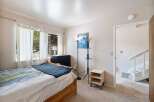 Discover this charming bedroom featuring a comfortable bed with a stylish blue throw blanket.