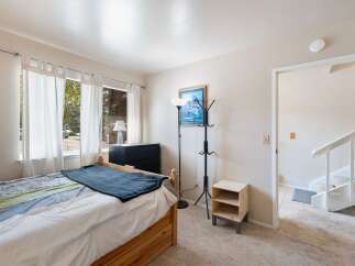 Discover this charming bedroom featuring a comfortable bed with a stylish blue throw blanket.