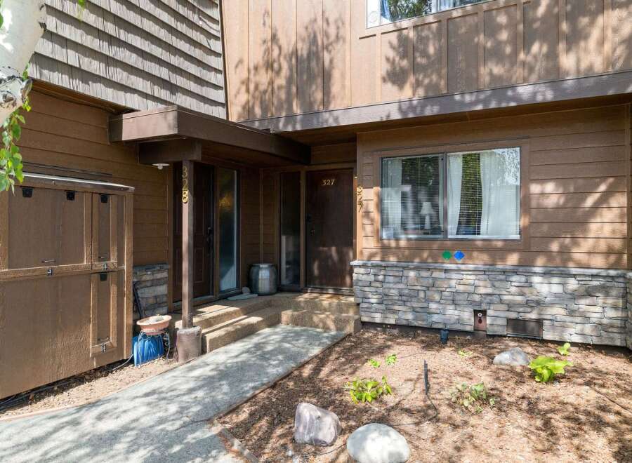 Discover this charming property featuring a warm brown exterior with natural wood siding and decorative stone accents.