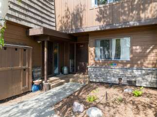 Discover this charming property featuring a warm brown exterior with natural wood siding and decorative stone accents.
