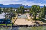 Enjoy lakeside living with this stunning property featuring a private beach volleyball court and multiple tennis courts for recreation.