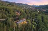 Nestled amidst a lush aspen and pine forest, this stunning mountain home offers breathtaking panoramic views of the surrounding peaks and a charming ski village below.