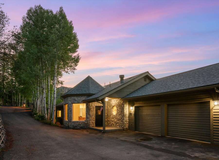Nestled amidst a serene forest setting, this unique stone home offers a captivating blend of rustic charm and modern comfort.