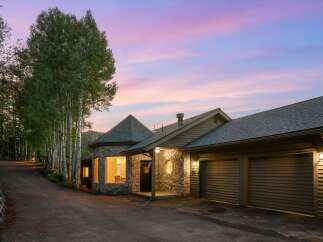 Nestled amidst a serene forest setting, this unique stone home offers a captivating blend of rustic charm and modern comfort.