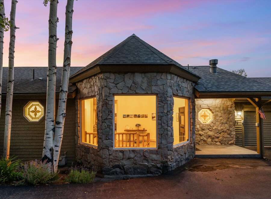 Experience the charm of this unique home featuring a striking stone facade and a distinctive octagonal turret with large windows.