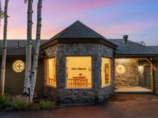 Experience the charm of this unique home featuring a striking stone facade and a distinctive octagonal turret with large windows.