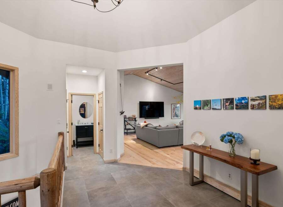 Step into this inviting entryway featuring a rustic wooden railing and a view into a modern living space.