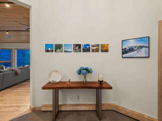 This entryway features a live-edge wood console table adorned with decorative items and a vase of blue hydrangeas.