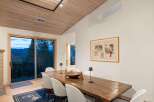 Experience breathtaking mountain views from this elegant dining room, featuring a rustic wooden table and chairs perfect for intimate gatherings.