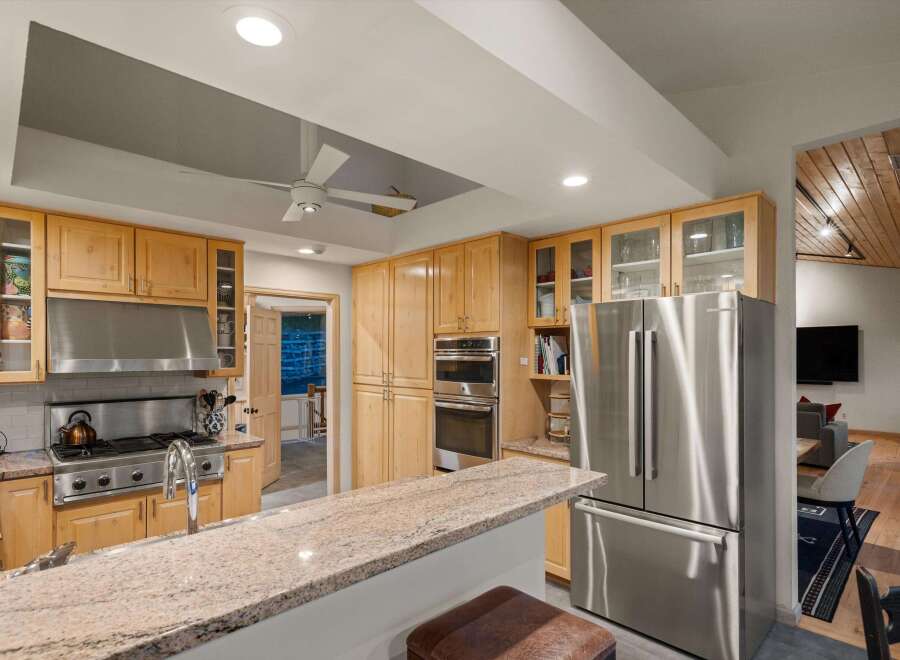 Experience culinary excellence in this stunning kitchen, featuring sleek stainless steel appliances, a professional-grade gas range, and ample custom cabinetry.