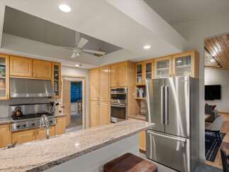 Experience culinary excellence in this stunning kitchen, featuring sleek stainless steel appliances, a professional-grade gas range, and ample custom cabinetry.