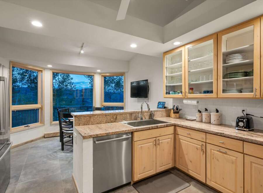 Experience breathtaking mountain views from this stunning kitchen, featuring a large bay window that floods the space with natural light.