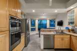 Experience breathtaking mountain views from this stunning kitchen, featuring a double oven and stainless steel refrigerator.