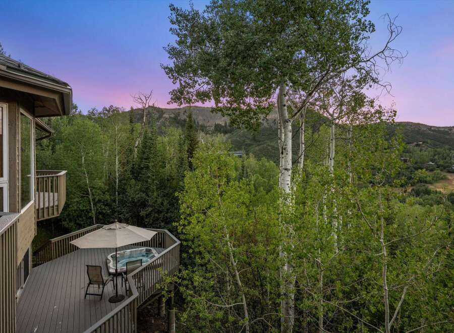 Experience ultimate relaxation on this expansive deck, complete with a luxurious hot tub and comfortable seating, perfect for enjoying the stunning mountain views.