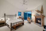 Experience ultimate comfort in this luxurious bedroom, featuring a cozy fireplace and a stunning mountain view from the sliding glass doors.