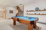 Enjoy endless entertainment in this finished basement, featuring a full-size pool table perfect for game nights.