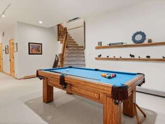 Enjoy endless entertainment in this finished basement, featuring a full-size pool table perfect for game nights.