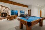 Experience ultimate relaxation and entertainment in this stunning basement living area, featuring a cozy stone fireplace and a full-size pool table for endless fun.