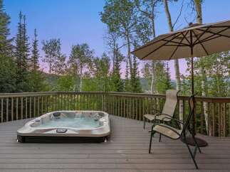 Experience ultimate relaxation on this spacious deck, featuring a luxurious hot tub perfect for soaking in the stunning mountain views.