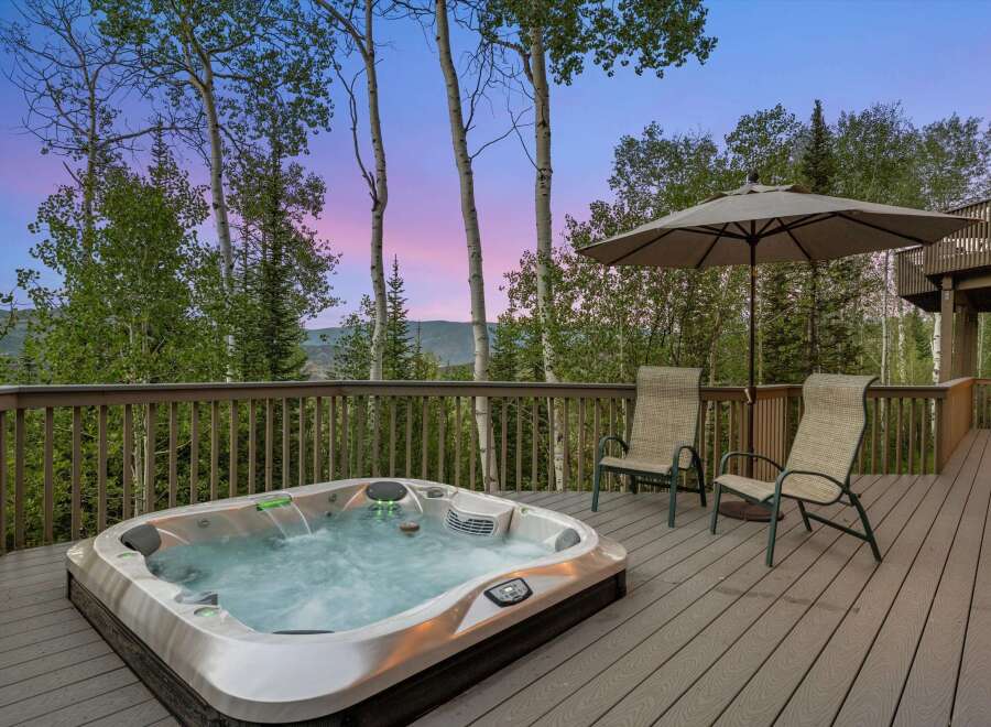 Experience ultimate relaxation on this spacious deck, featuring a luxurious hot tub perfect for unwinding amidst breathtaking mountain views.
