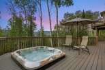 Experience ultimate relaxation on this spacious deck, featuring a luxurious hot tub perfect for unwinding amidst breathtaking mountain views.