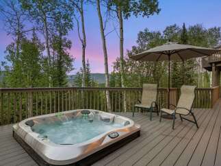 Experience ultimate relaxation on this spacious deck, featuring a luxurious hot tub perfect for unwinding amidst breathtaking mountain views.