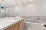 Experience modern luxury in this stunning bathroom, featuring a sleek vanity with ample counter space and a deep soaking tub perfect for relaxation.