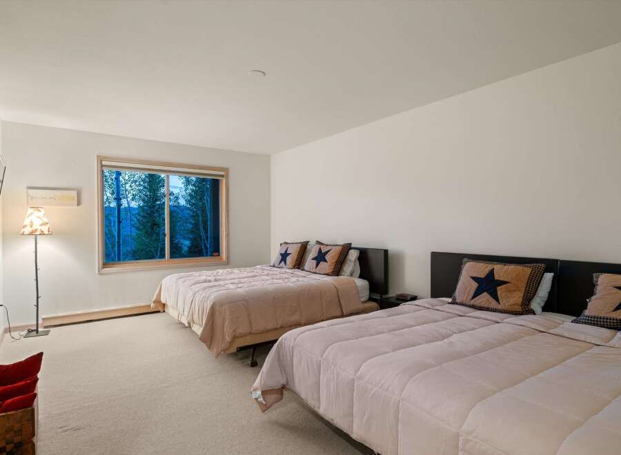 This spacious bedroom features two queen-sized beds, perfect for accommodating family or guests.