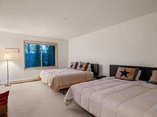 This spacious bedroom features two queen-sized beds, perfect for accommodating family or guests.