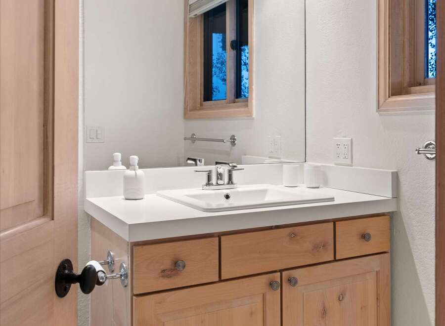 This bathroom features a light wood vanity with ample storage, topped with a clean white countertop.