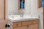 This bathroom features a light wood vanity with ample storage, topped with a clean white countertop.