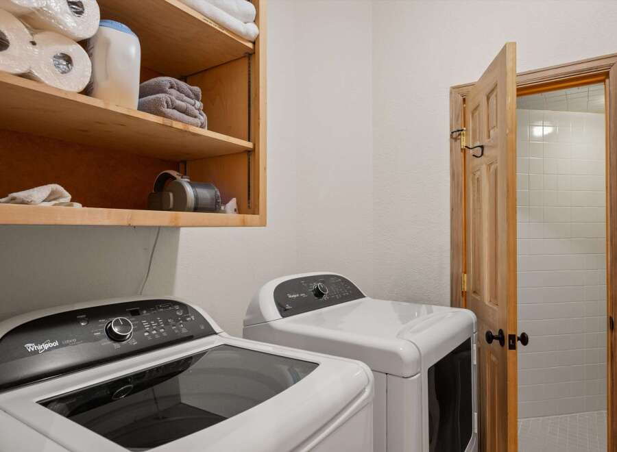 This laundry room features a Whirlpool Cabrio top-load washer and a matching dryer, perfect for handling family-sized loads.