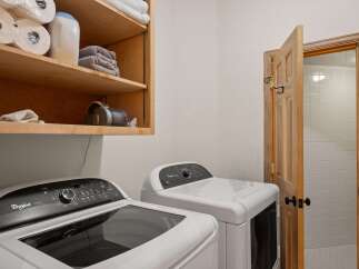 This laundry room features a Whirlpool Cabrio top-load washer and a matching dryer, perfect for handling family-sized loads.