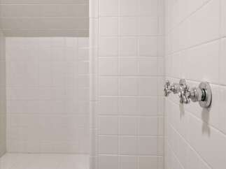 Step into this pristine white tiled shower, featuring a built-in bench for ultimate comfort and relaxation.