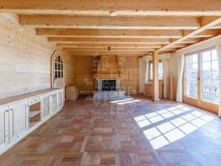 Experience rustic charm in this beautifully appointed wooden living room, featuring a grand stone fireplace as the centerpiece.