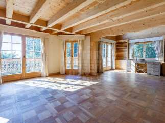 Experience rustic charm in this spacious room featuring a beautiful wooden beamed ceiling and elegant parquet flooring.