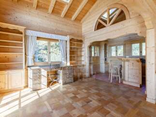 Experience rustic charm in this beautifully appointed wooden interior, featuring a spacious desk area with ample storage and a cozy bar with stools.