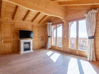 Experience rustic charm in this beautifully appointed wooden cabin room, featuring a modern fireplace and entertainment center.