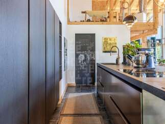 Discover a modern kitchen with dark wood cabinetry and sleek countertops, perfect for culinary enthusiasts.