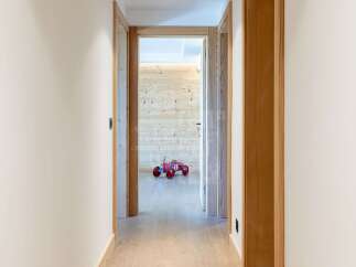 Step into a charming hallway featuring warm wooden accents and a playful red toy car.