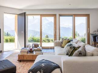 Experience breathtaking mountain views from this stunning living room, featuring expansive sliding glass doors that seamlessly blend indoor and outdoor living.