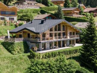 Experience luxury mountain living in this stunning wooden chalet, featuring expansive glass windows and a wrap-around balcony offering breathtaking views.