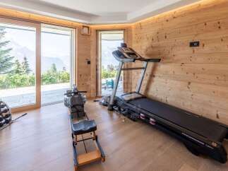 Elevate your wellness routine in this stunning home gym, featuring a professional treadmill and rowing machine.