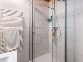Experience modern comfort in this bathroom featuring a sleek glass-enclosed shower and a convenient heated towel rack.